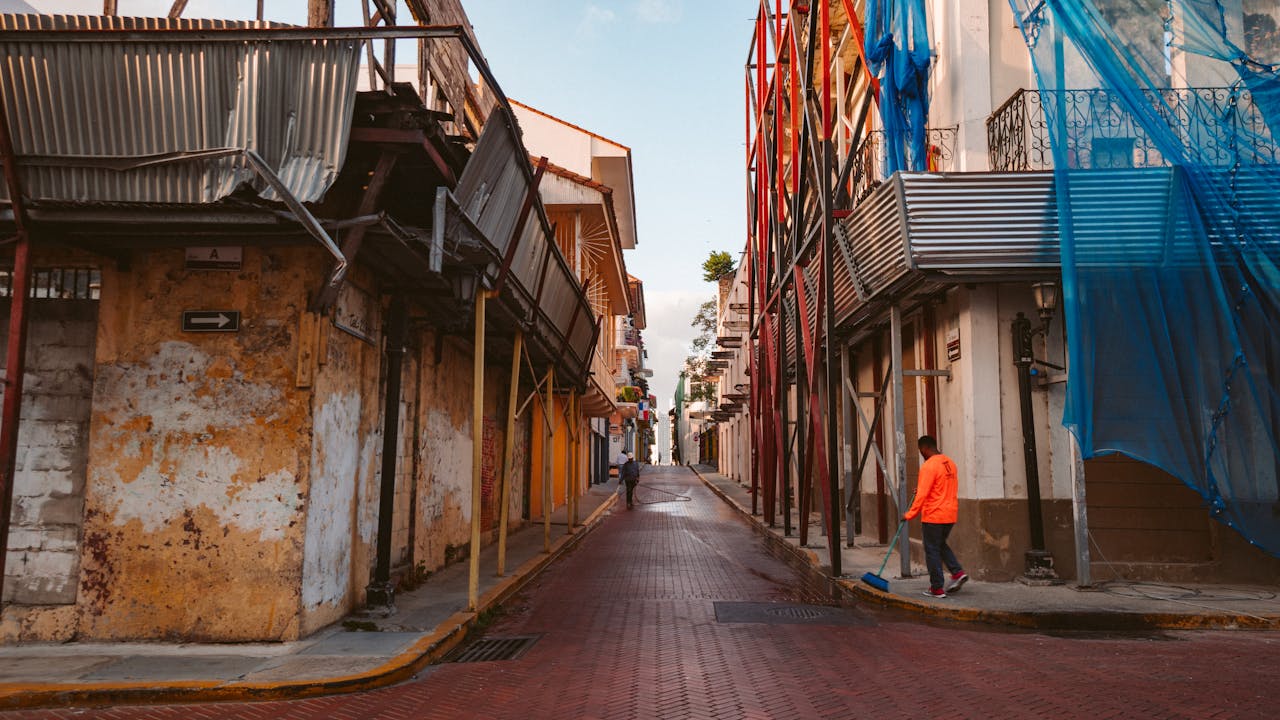 Quiet cobblestone street with renovations and scaffolding in an old town, capturing urban change.